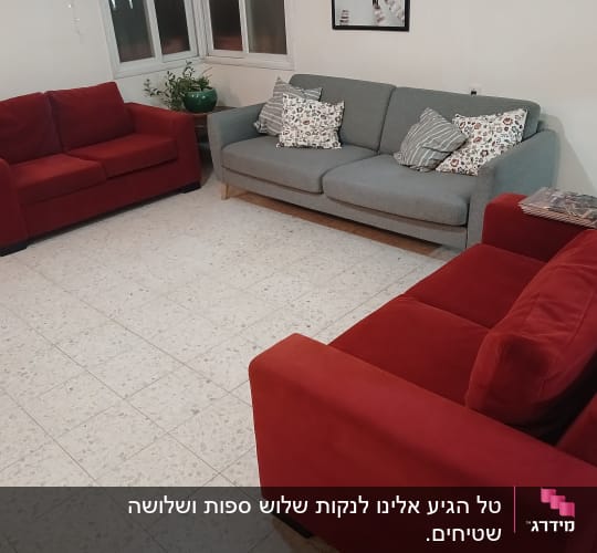 ספות אדומות ואפורה בחדר עם רצפת אריחים